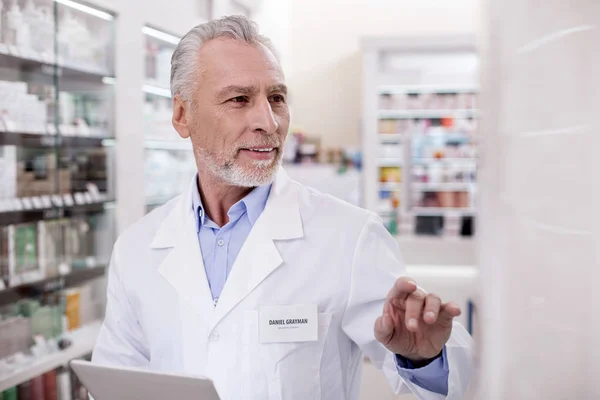 Attentive male pharmacist checking online catalog — Stock Photo, Image