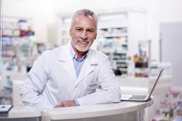 Farmacéutico masculino positivo trabajando en farmacia —  Fotos de Stock