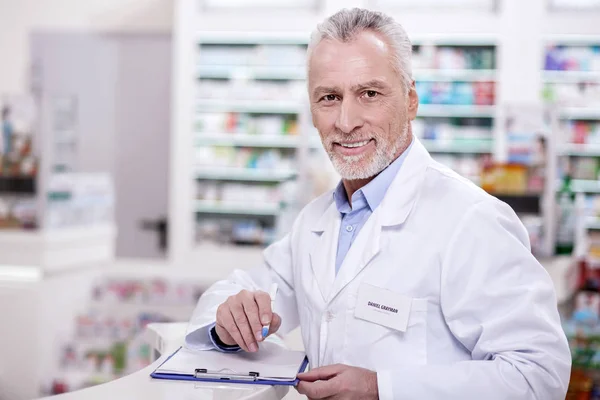 Optymistyczne mężczyzna farmaceuty, wypełniania dokumentacji — Zdjęcie stockowe
