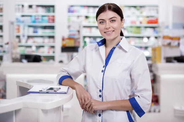 Jolly female pharmacist saluting clients — Stock Photo, Image