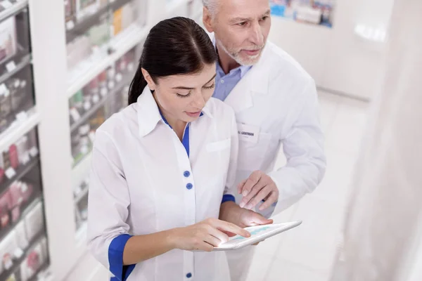 Pensativo dos farmacéuticos ayudándose mutuamente —  Fotos de Stock