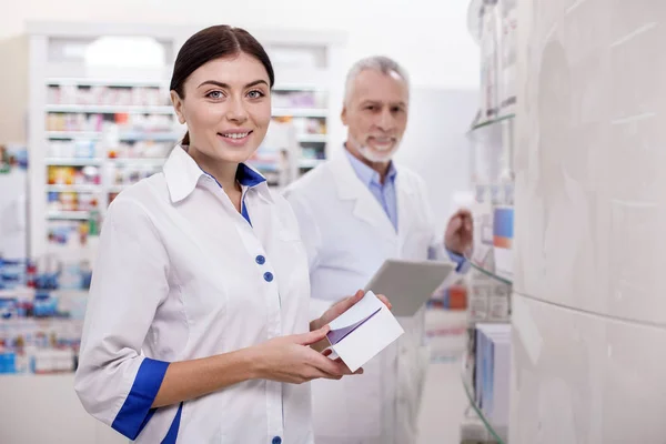 Glückliche Apothekerin, die Medikamente überwacht — Stockfoto