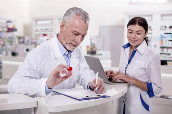 Senior male doctor helping pharmacist — Stock Photo, Image