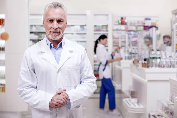 Trevlig manlig apotekspersonal tarrying klienter — Stockfoto