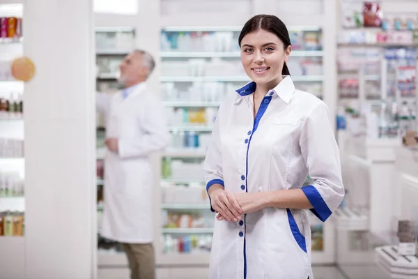 Jolly female pharmacist working in drugstore — Stock Photo, Image