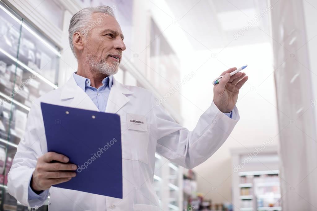 Confident male pharmacist checking presents