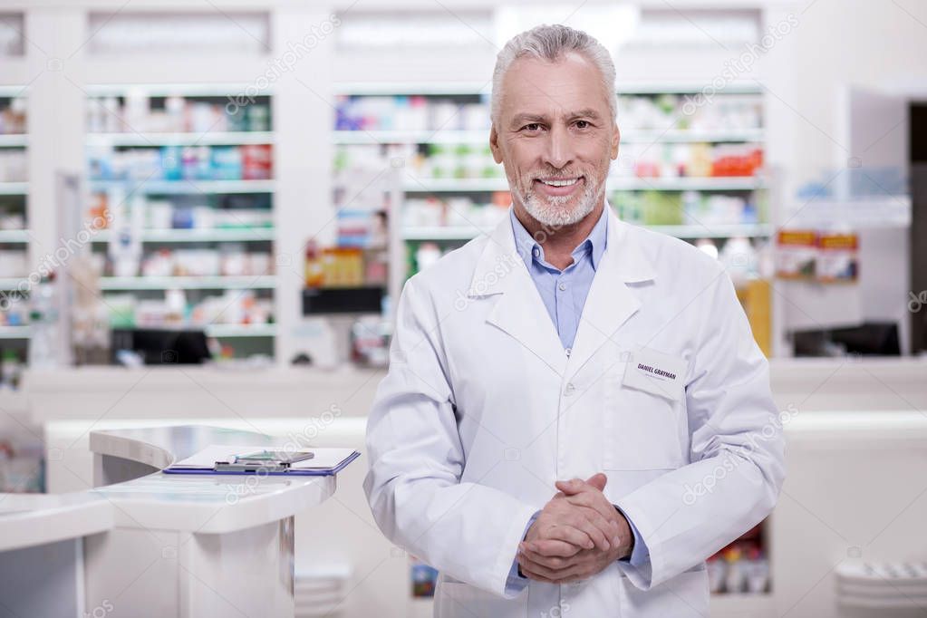 Handsome male pharmacist greeting in drugstore