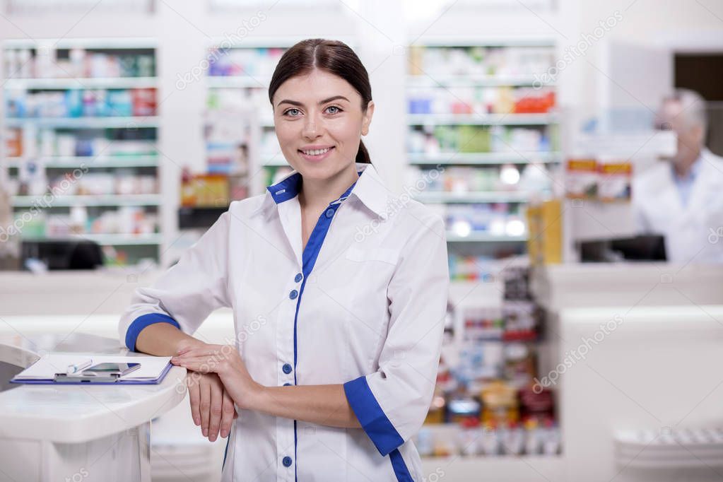 Joyful female pharmacist reviewing clients