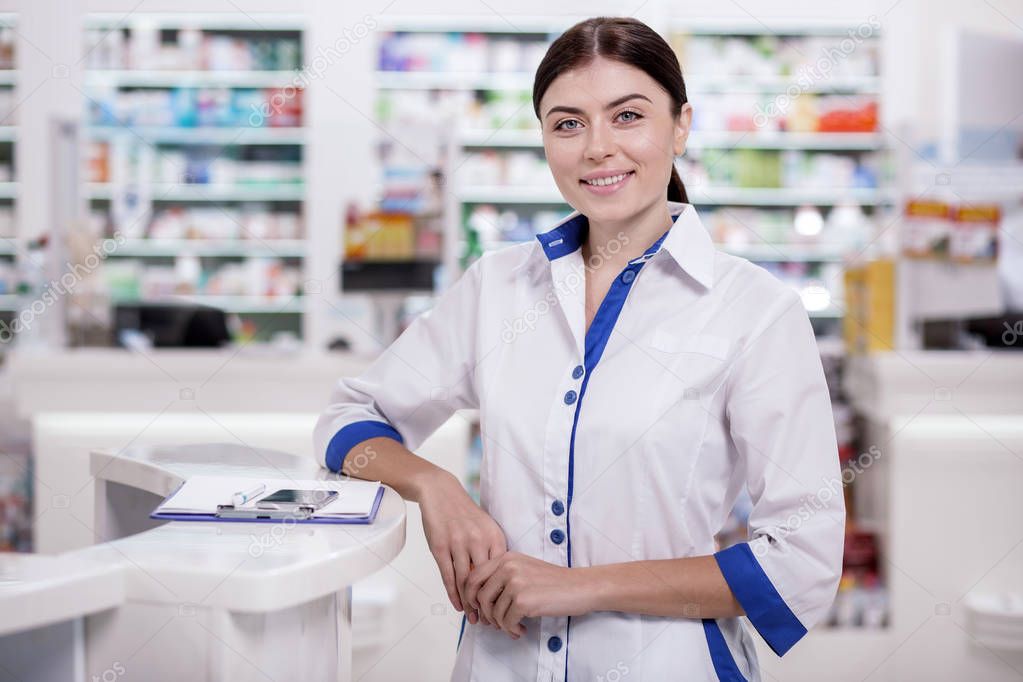 Jolly female pharmacist saluting clients