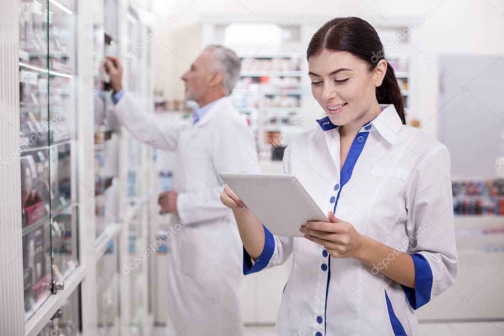 Happy female pharmacist creating electronic system
