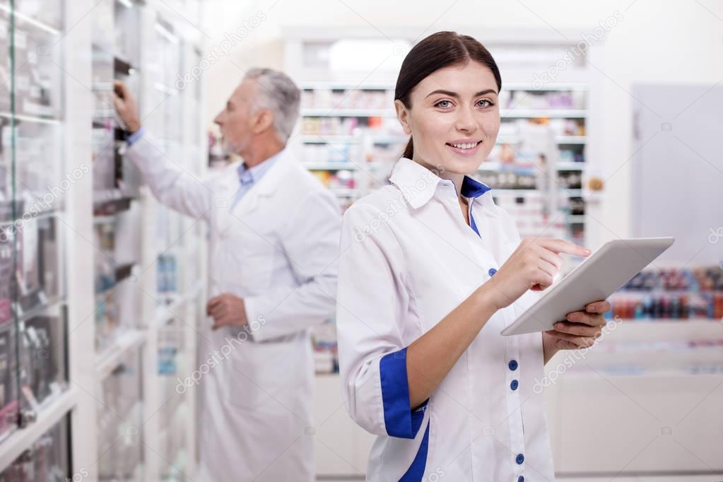 Charming female pharmacist developing electronic system