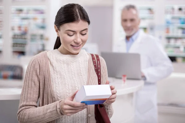 Cliente femenino enfocado verificando droga — Foto de Stock