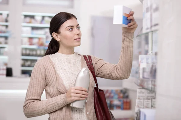 약물을 선택 하는 사려깊은 여성 고객 — 스톡 사진