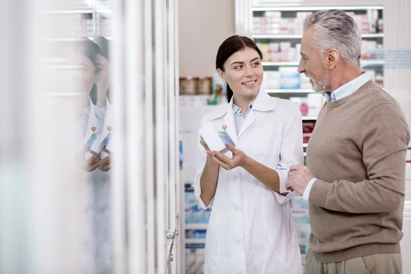 Farmacéutica positiva ayudando a hombre mayor —  Fotos de Stock