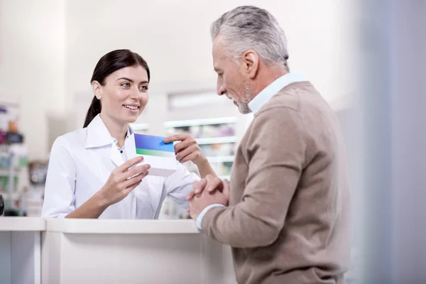 Pleasant female pharmacist proposing drug — Stock Photo, Image