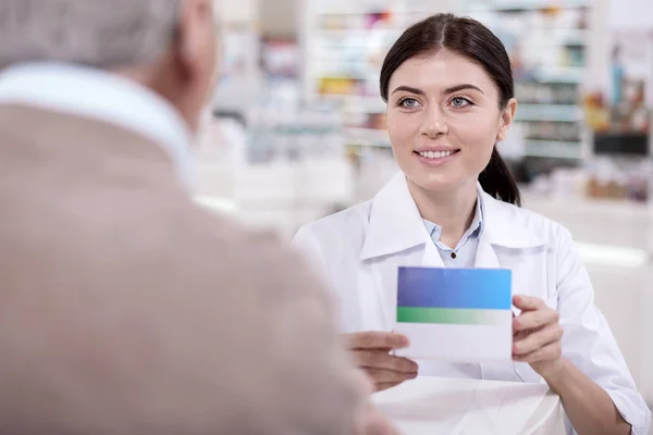 Merry female pharmacist warning about side effects — Stock Photo, Image