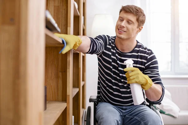 Wesoły niepełnosprawny mężczyzna, sprzątanie swojego pokoju — Zdjęcie stockowe