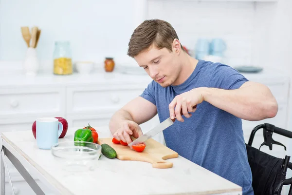 Aufmerksame männliche Person schneidet Gemüse — Stockfoto