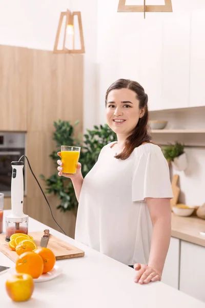 Mujer jovial inspirada disfrutando de naranja fresca — Foto de Stock