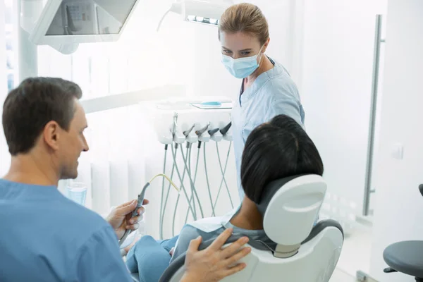 Professionele tandarts kijken naar haar patiënt — Stockfoto