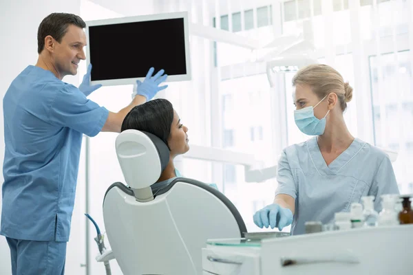 Dentista gentil olhando para seu paciente — Fotografia de Stock