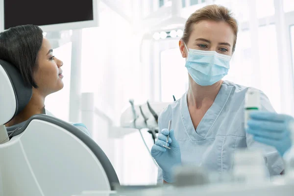 Dentista serio sosteniendo un instrumento — Foto de Stock