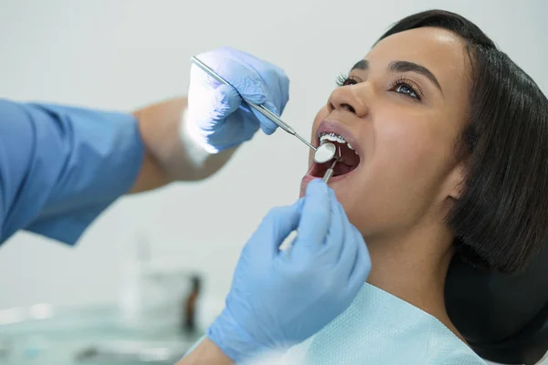 Geconcentreerde patiënt zit met haar mond geopend — Stockfoto