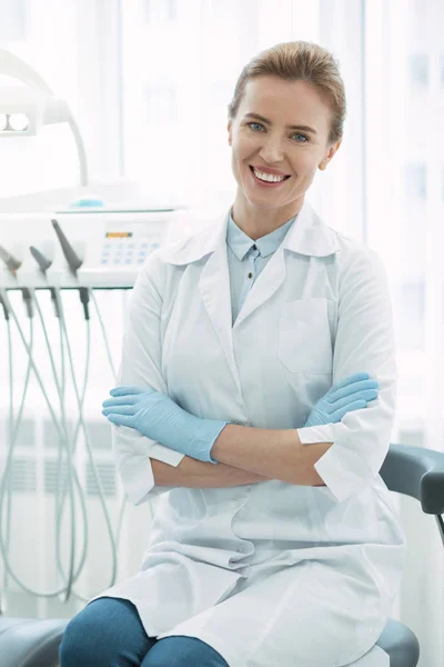 Натхненний стоматолог сидить з схрещеними руками — стокове фото