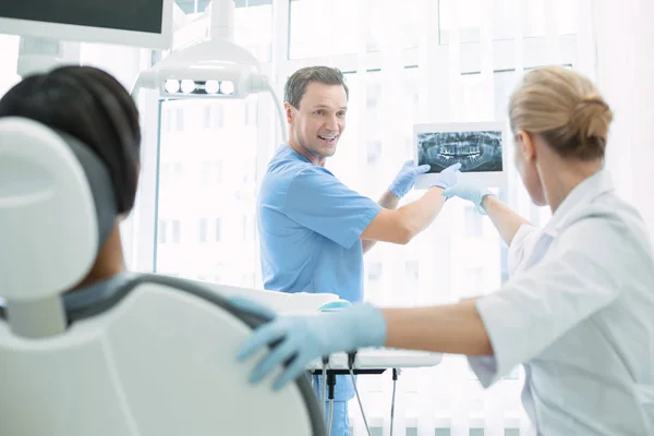 Content dentist showing teeth on the screen — Stock Photo, Image