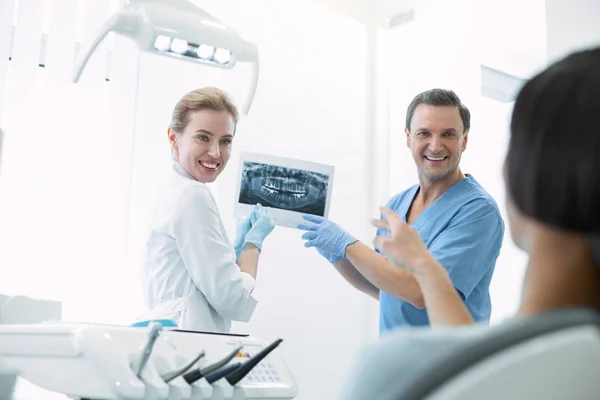 Dentistas encantados mostrando dentes na tela — Fotografia de Stock