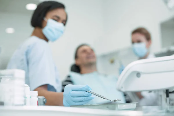 Geschoolde vrouwelijke tandarts houden een instrument — Stockfoto