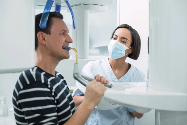 Professional female dentist watching her patient