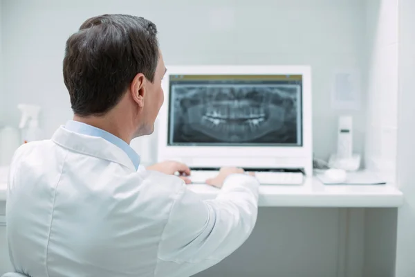 Geïnspireerd tandarts werken aan zijn geavanceerde technologie — Stockfoto