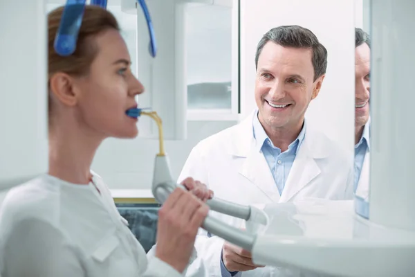 Odontólogo alegre mirando a su paciente — Foto de Stock