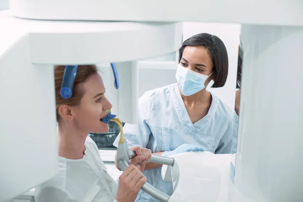 Delighted dentist watching her patient — Stock Photo, Image