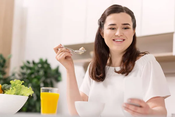 Piacevole donna meditativa degustazione porridge — Foto Stock