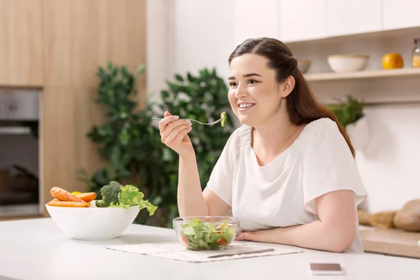 Счастливая веселая женщина дегустирует салат — стоковое фото