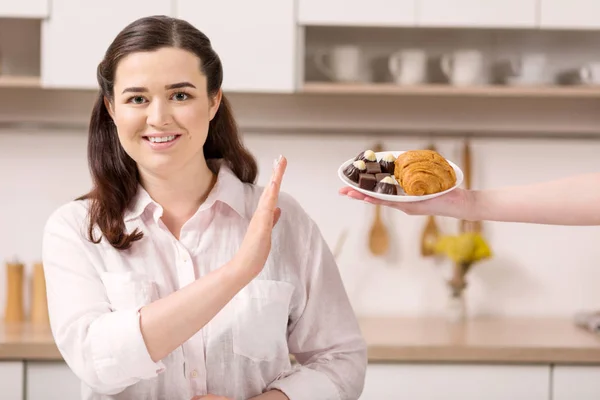 Confident strong woman refusing from croissant — Stock Photo, Image
