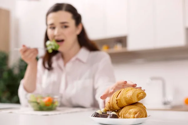 Mujer preocupada molesto admirando croissant — Foto de Stock