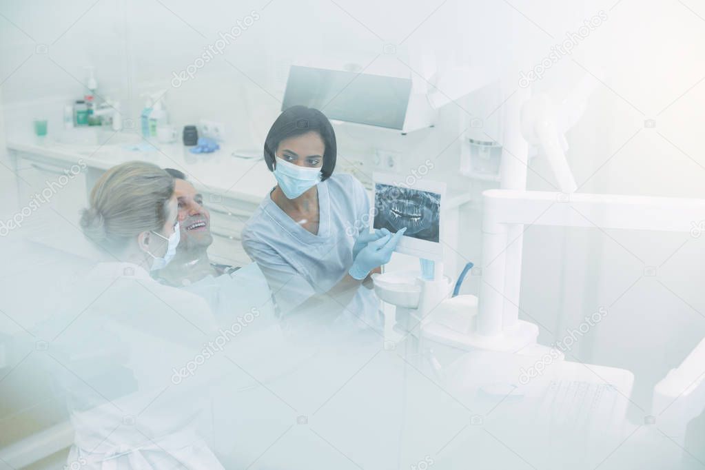 Skilled female dentists discussing work