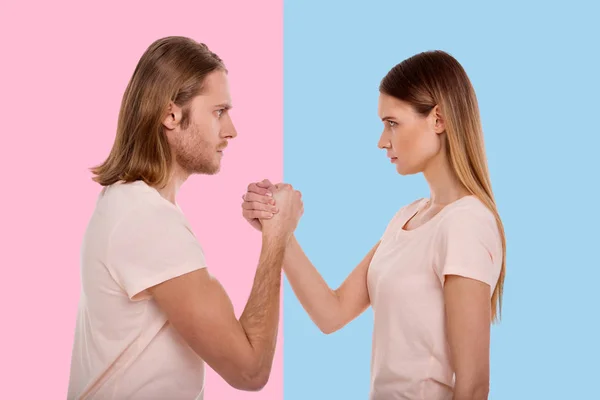 Geconcentreerde jonge man en vrouw arm-wrestling — Stockfoto