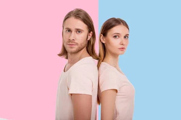 Pleasant young couple posing back-to-back — Stock Photo, Image