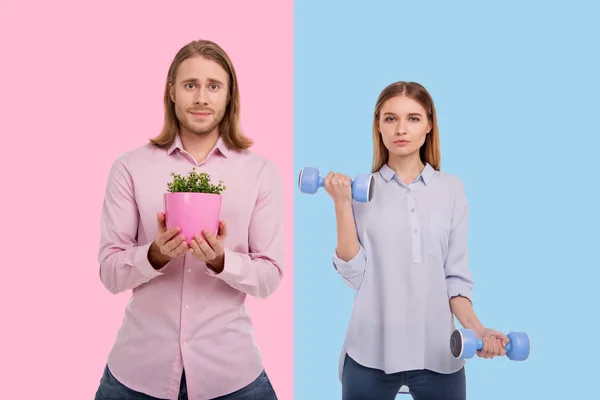 Encantador homem segurando planta enquanto mulher exercitando com halteres — Fotografia de Stock