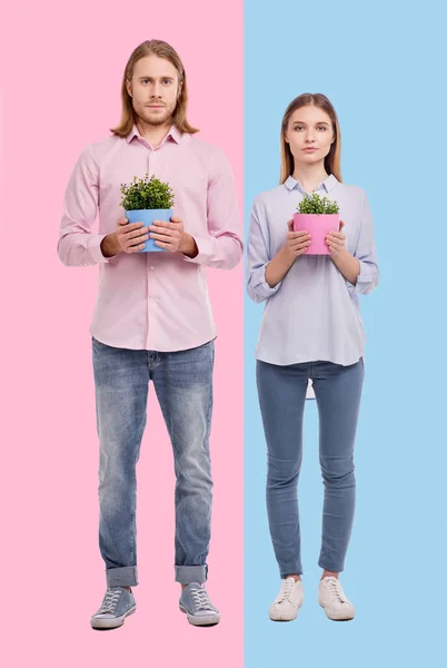 Giovane donna e uomo in posa con vasi di fiori — Foto Stock