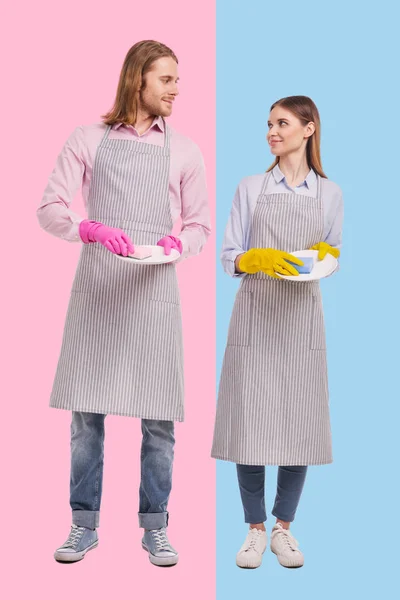 Affascinante coppia sorridente a vicenda mentre si lava i piatti — Foto Stock