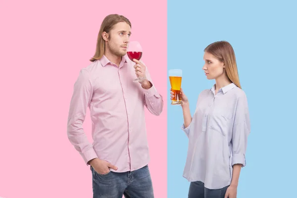 Pleasant man sniffing wine while his girlfriend holding beer — Stock Photo, Image