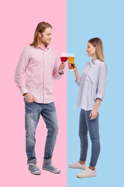 Young man with wine clinking glasses with woman having beer — Stock Photo, Image