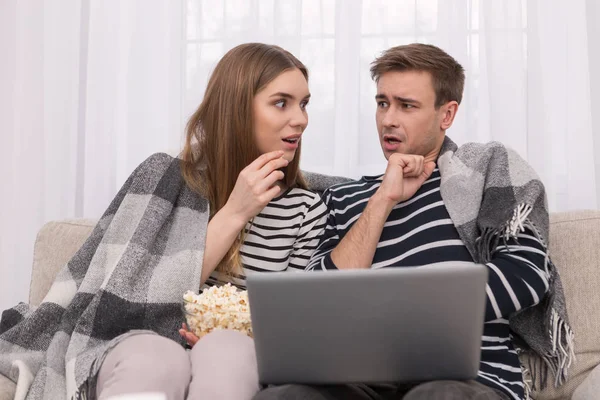 Verbaasd vrouw en man kijken naar een film — Stockfoto
