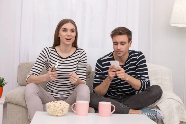 Geïnspireerd vrouw kijken naar een film met haar vriendje — Stockfoto