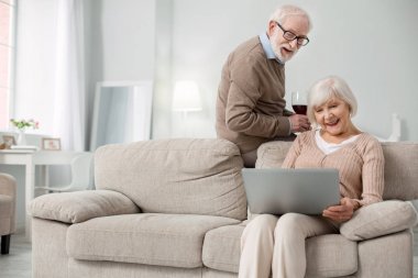 Onu laptop kullanan memnun yaşlı kadın